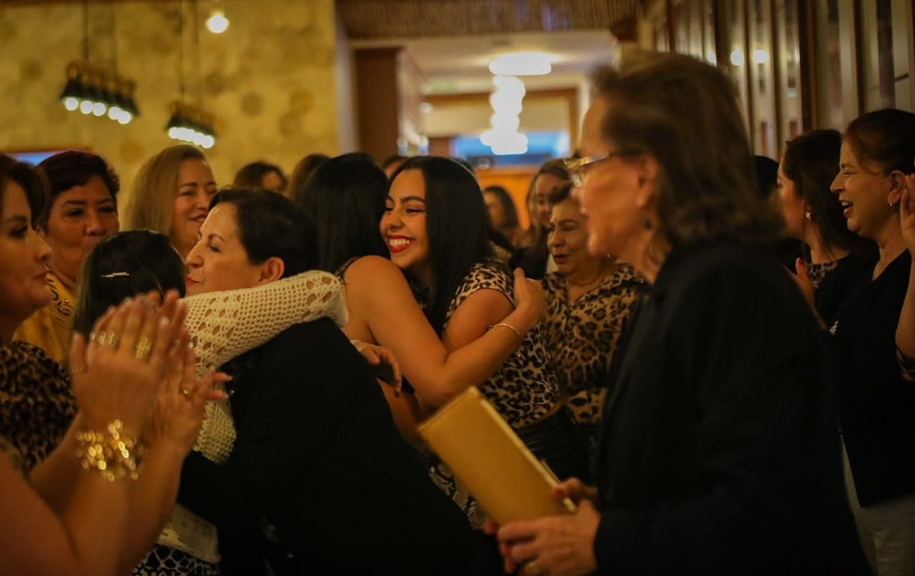 Mujeres abrazándose y aplaudiendo durante la celebración nocturna de Andariegas